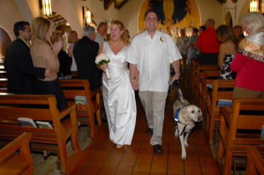 couple walking down aisle with dog